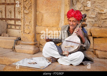 Portrait of india musician wearing a read turban playing on the street, Jaisalmer, Rajasthan, India Stock Photo