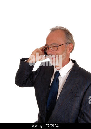 A middle age smiling business man in a suit, talking on his cell phone, isolated for white background. Stock Photo