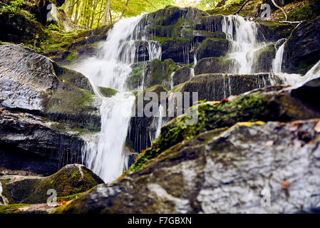 Waterfall among rocks in rocky high mountains Stock Photo