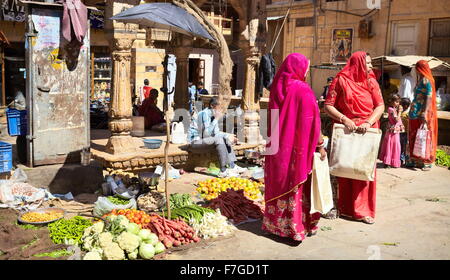 Jaislamer street scene with two india hindu women in red sari on the market, Jaisalmer, India Stock Photo