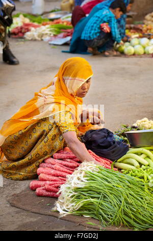 Jaisalmer street scene with india hindu woman in sari selling vegetables on the street market, Jaisalmer, India Stock Photo