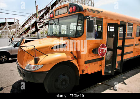 School bus parked while the kids visit the  theme park of Coney Island Stock Photo