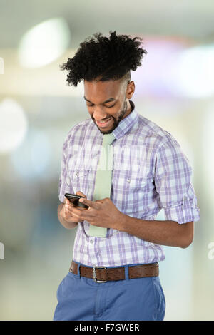 Portrait of young African American businessman using cellphone inside building Stock Photo