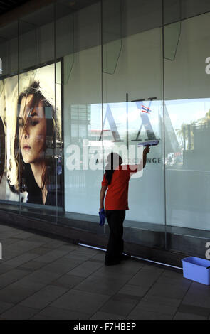 Female cleaning windows at The Central Festival Asia’s largest beachfront shopping centre in Pattaya Thailand Stock Photo