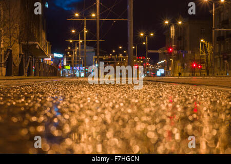 Tram line rails by night. Blurred view with selective focus from the ground level Stock Photo