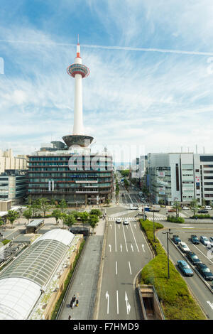 Sunny blue sky with Kyoto Tower and nearby city buildings and neat streets in front of Kyoto Station in Japan Stock Photo