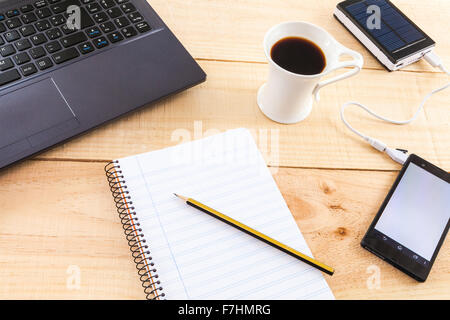 Collection of objects of an freelance worker or someone who works at home, on wooden background illuminated with natural light a Stock Photo