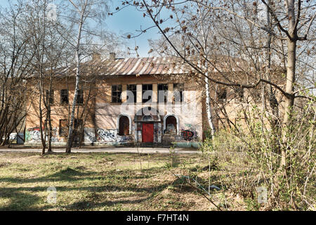 abandoned building with graffiti in spring garden Stock Photo