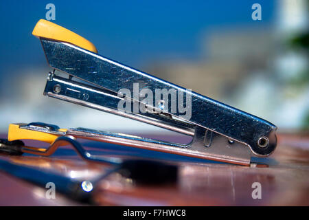 Simple Machine : Close - up of a stapler laying on a writing Pad. Stock Photo