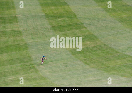 A small boy runs on the massive grassy slopes at the National Arboretum in Canberra, Australia Stock Photo