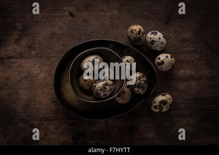 Quail eggs in a bowl on a wooden table Stock Photo