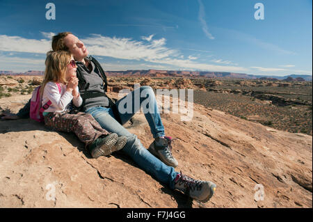 Mother and daughter resting on rock in Canyonlands National Park, Utah, USA Stock Photo