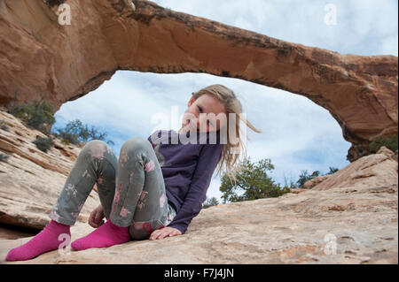 Girl sitting near Owachomo Bridge, Natural Bridges National Monument, Utah, USA Stock Photo