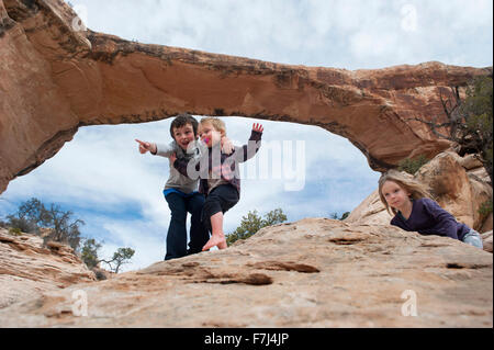 Children exploring near Owachomo Bridge, Natural Bridges National Monument, Utah, USA Stock Photo