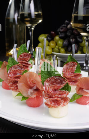 Canape of watermelon balls with a melon with gammon and salami Stock Photo