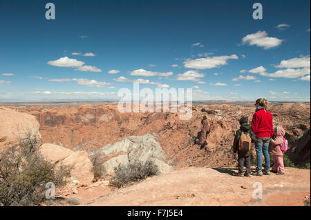 Mother and children standing at edge of canyon in Canyonlands National Park, Utah, USA Stock Photo