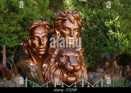 Bronze Siegfried and Roy bust outside the Mirage hotel on Las Vegas Boulevard with green bushes behind and a green fence Stock Photo