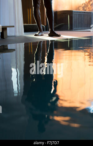 Man's reflection on spa swimming pool, low section Stock Photo