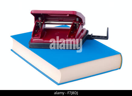 Red hole punch paper lies on the blue book Stock Photo