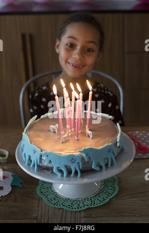 Girl preparing to blow out candles on birthday cake Stock Photo