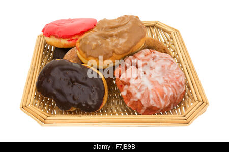 An old wicker basket filled with assorted donuts and iced cherry fritter on a white background. Stock Photo