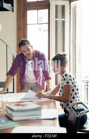Architect discussing project blueprints with colleague Stock Photo