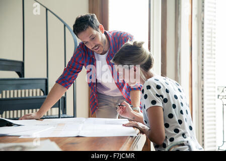 Wife and husband reviewing blueprints for home renovation Stock Photo