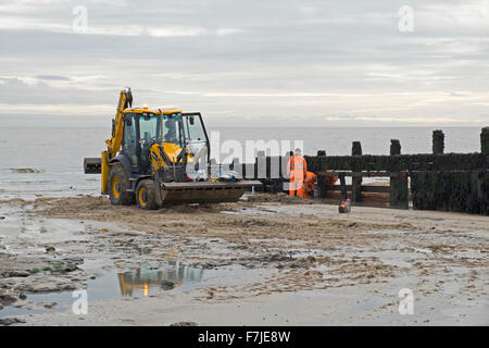 repairing wooden groyne beach walton naze essex, groynes are sturdy barriers built out into the sea from a beach to check erosion and drifting. Stock Photo