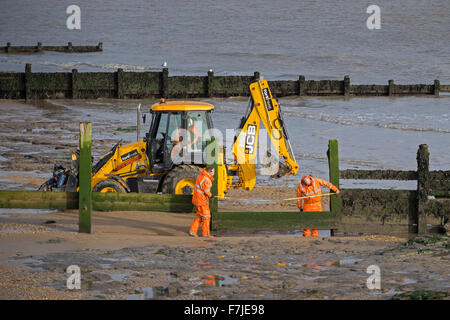 repairing wooden groyne beach walton naze essex, groynes are sturdy barriers built out into the sea from a beach to check erosion and drifting. Stock Photo