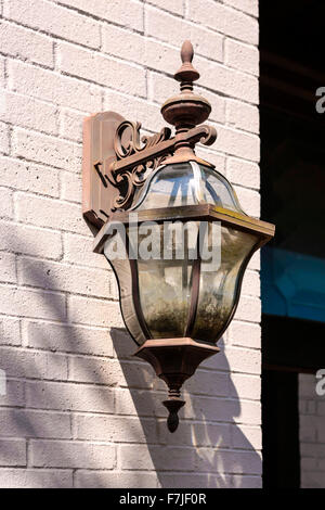 An old rusting gas coach lantern on the wall of an abandoned building Stock Photo