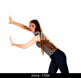 Woman pushing something imaginary isolated over a white background. Stock Photo