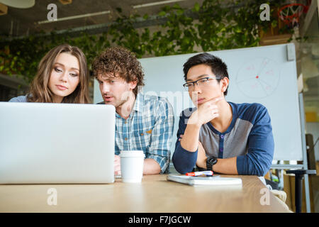 Confident concentrated students learning and studying with laptop in classroom Stock Photo