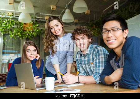 Group of modern happy excited businesspeople having a meeting and using laptop in conference room Stock Photo
