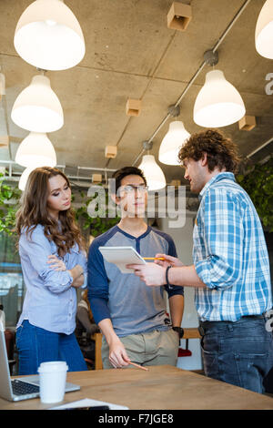 Young ambitious team of people working on new project together in the office Stock Photo