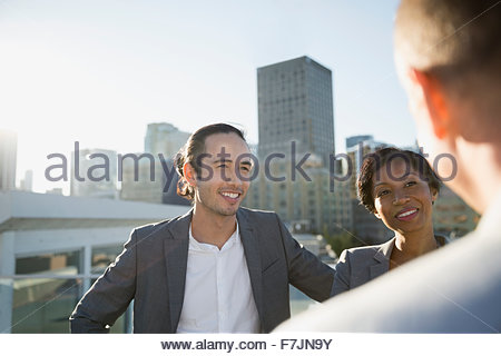 Business people talking on sunny urban rooftop