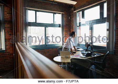 Pensive businessman looking out office window