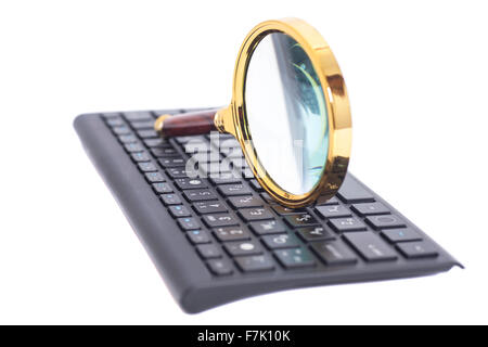 Magnifying Glass on black keyboard isolated Stock Photo