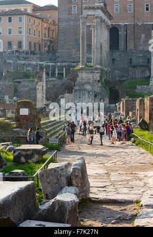 Rome, Italy.  Visitors in the Roman Forum walking towards the ruins of the Temple of Saturn. Stock Photo