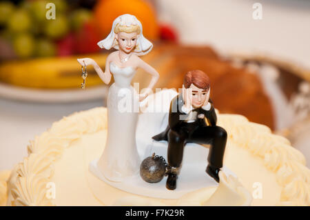 Wedding Cake Topper Funny, bride holding the keys of the ball with which he has roped groom Stock Photo