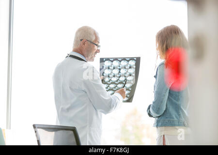Doctor reviewing x-rays with patient in doctor’s office Stock Photo