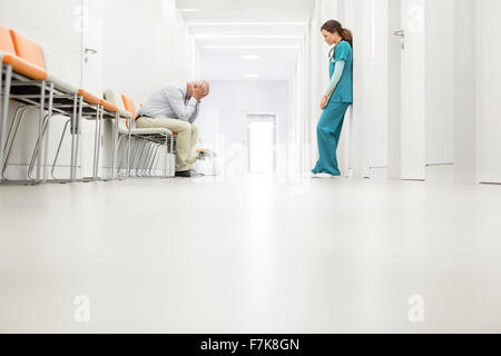 Stressed doctor and nurse in hospital corridor Stock Photo