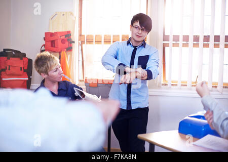 Instructor guiding students on making medical splint in training class Stock Photo