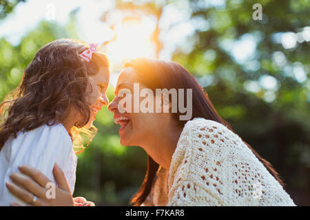 Enthusiastic mother and daughter smiling face to face Stock Photo