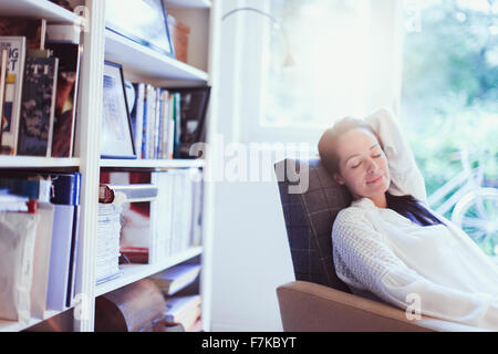 Serene woman napping in armchair Stock Photo