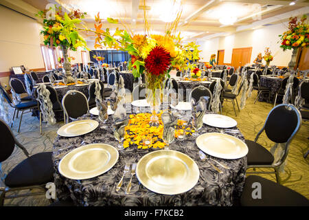 EUGENE, OR - SEPTEMBER 13, 2014: Wedding reception dinner talbe setup and ready for guests with a wedding coordinator and her as Stock Photo