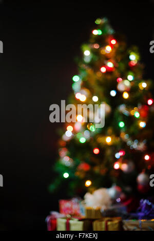 Colorful Christmas background of de-focused lights with decorated tree. Stock Photo