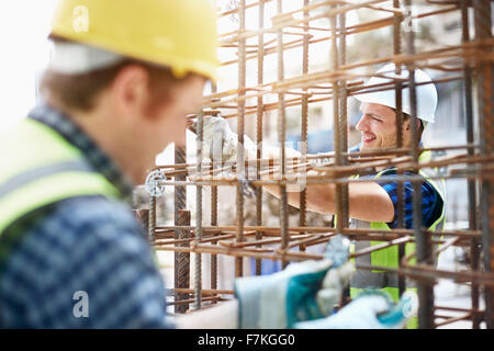 Constructor workers assembling rebar structure at construction site Stock Photo