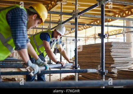 Construction workers adjusting metal bar at construction site Stock Photo