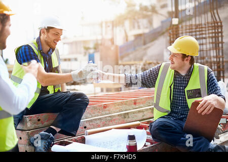 Construction workers and engineer enjoying coffee break at construction site Stock Photo