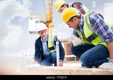 Construction workers and engineer using level tool at construction site Stock Photo